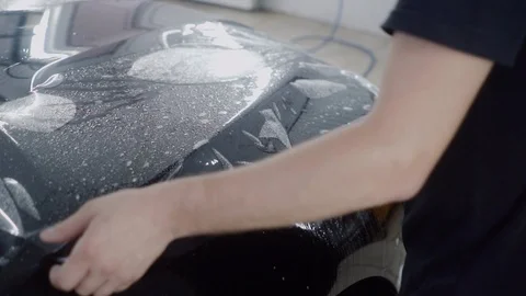 The master applies a protective layer on the surface of the car Stock Footage 93621971