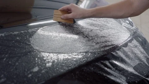 The master applies a protective layer on the surface of the car Stock Footage 93622103