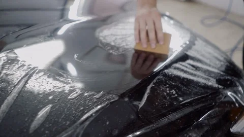 The master applies a protective layer on the surface of the car Stock Footage 93622174