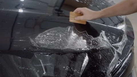The master applies a protective layer on the surface of the car 動画素材 93622260