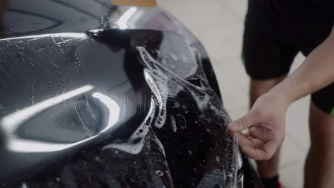 The master applies a protective layer on the surface of the car Stock Footage 93622391