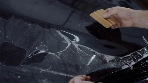 The master applies a protective layer on the surface of the car Stock Footage 93622493