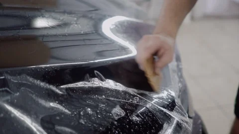 The master applies a protective layer on the surface of the car Stock Footage 93622562