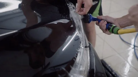 The master applies a protective layer on the surface of the car Stock Footage 93622760