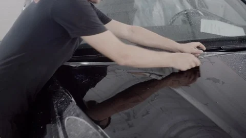 The master applies a protective layer on the surface of the car Stock Footage 93626029