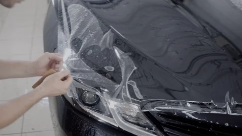 The master applies a protective layer on the surface of the car Stock Footage 93626192