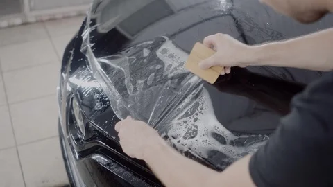The master applies a protective layer on the surface of the car Stock Footage 93627550
