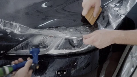 The master applies a protective layer on the surface of the car Stock Footage 93628381