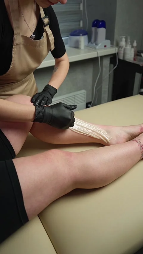 The master applies a Sugar Paste for Depilation on the feet of the client Stock-Footage 239326448