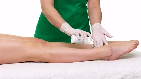 The master applies a white sugar scrub before depilating the skin on female leg Stock Footage 267453940