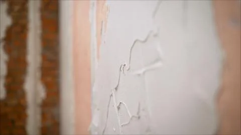 Master is applying white putty on a wall and smearing by putty knife in a roo Stock Photos