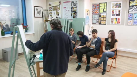 A master of the art school explains to students painting Stock Footage 144935928