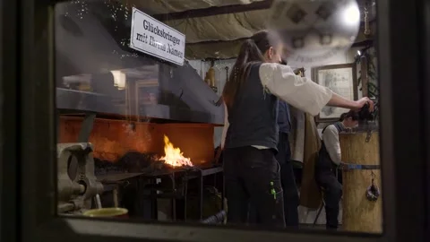 Master Artisan Carefully Shaping Glowing Metal Amidst Antique Equipment And Stock Footage 328045347