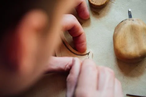 Master artisan luthier working on the creation of a violin. painstaking detailed Stock Photos