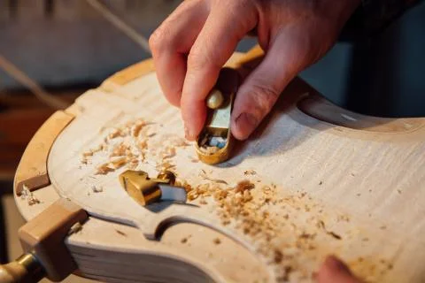 Master artisan luthier working on the creation of a violin. painstaking detailed Stock Photos
