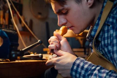 Master artisan luthier working on the creation of a violin. painstaking detailed Stock Photos