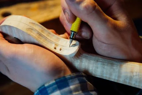 Master artisan luthier working on the creation of a violin. painstaking detailed Stock Photos