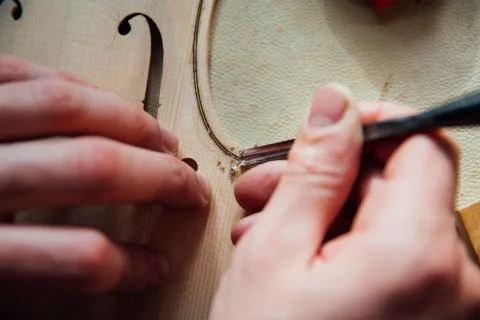 Master artisan luthier working on the creation of a violin. painstaking detailed Stock Photos