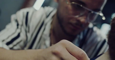 Master barber shortens and arranges a client's beard in a beauty salon Stock Footage 139701399