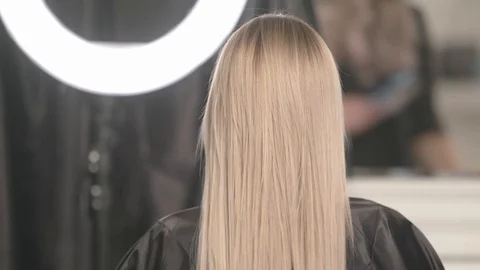 The master in the beauty salon combs the beautiful blonde hair Stock Footage 101598058