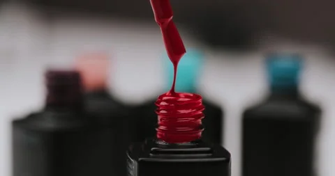 Master in black gloves holds red nail polish with an open bottle Stock Footage 149367987