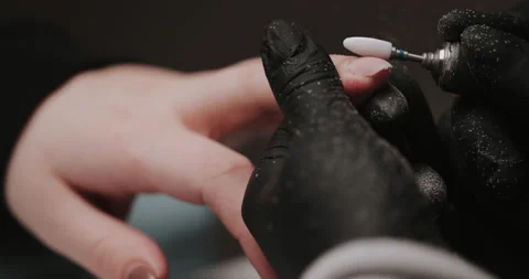 Master in black gloves making manicure using electric equipment for nails. Video stock 149365449