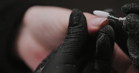 Master in black gloves making manicure using electric equipment for nails. Video stock 149365743