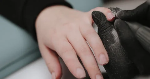 Master in black gloves making manicure using electric equipment for nails. Video stock 149365866