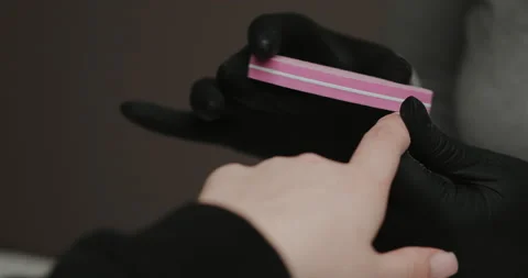 Master in black gloves making manicure using electric equipment for nails. Video stock 149365935