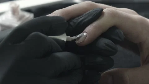 The master in black latex protective gloves dips a brush in a tube with a beige Stock Footage 141878738