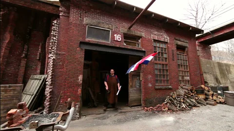 Master blacksmith stands in entryway of his historic shop, slider, wide shot Stock Footage 39022407