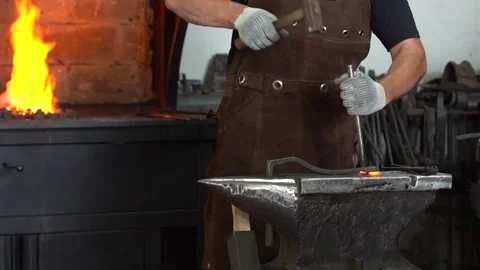 Master Blacksmith at Work Crafting Metal Objects with Hammer and Anvil Stock Footage 341316867