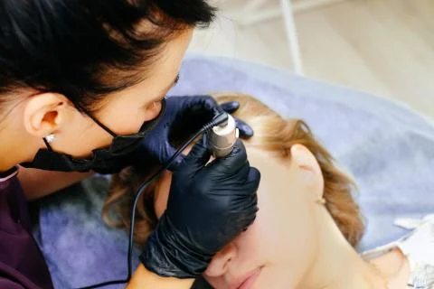 Master brow artist makes permanent eyebrow makeup in the technique of powder  Stock Photos