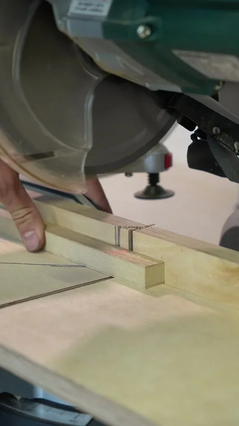 Master builder cuts a wooden plank on a miter saw Stock Footage 317414700