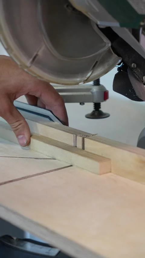 Master builder cuts a wooden plank on a miter saw Stock Footage 317414706