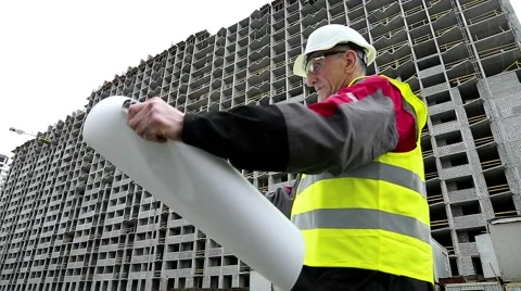 Master builder with design drawings at construction site Stock Footage 50600495