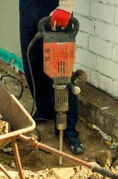Master Builder-finisher in work clothes, with a perforator in his hands Stock Photos