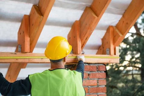 Master builder steadies ceiling timber during roof lag assembly, careful ha.. Stock Photos