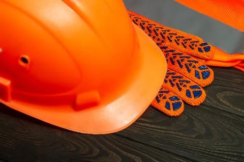 Master builder's orange protective equipment stacked on black boards Stock Photos