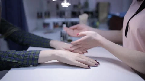 Master in the cabin makes the manicure and hand massage of young girl Stock-Footage 61440482