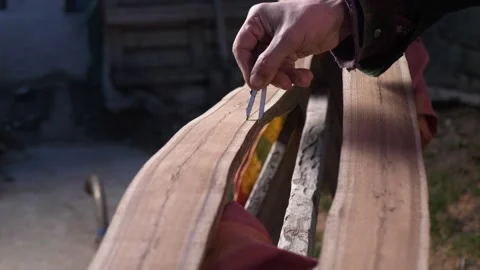 A master cabinetmaker marks with a compass on a half of a processed log for Stock Footage 244990627