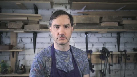 Master carpenter in an apron in his workshop. Small business Stock Footage 102567593