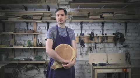 Master carpenter in an apron in his workshop. Small business Stock Footage 102567610