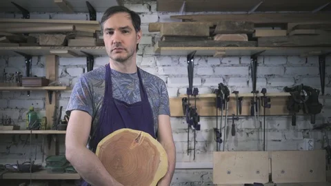 Master carpenter in an apron in his workshop. Small business Stock Footage 102567701