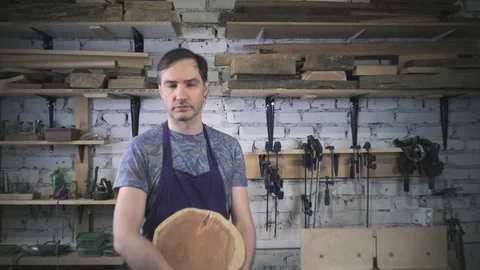 Master carpenter in an apron in his workshop. Small business Stock Footage 102567756