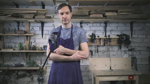 Master carpenter in an apron in his workshop. Small business Stock Footage 102567780