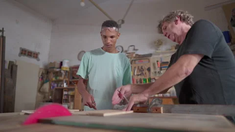 Master carpenter guiding student apprentice at carpentry workshop, job occu.. Video stock 246765354