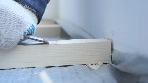 Master carpenter mounts pine wood floor - eco-friendly flooring. screwing lag to Stock Footage 107169373