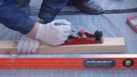 Master carpenter mounts pine wood floor - eco-friendly flooring. screwing lag to Stock Footage 107443314
