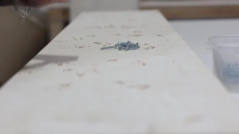 Master carpenter quickly drives metal screws into wooden board with screwdriver Stock Footage 271639970